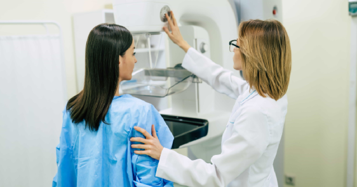 Female patient receiving a painless mammogram in Dallas, TX, guided by a medical professional using modern breast screening equipment.