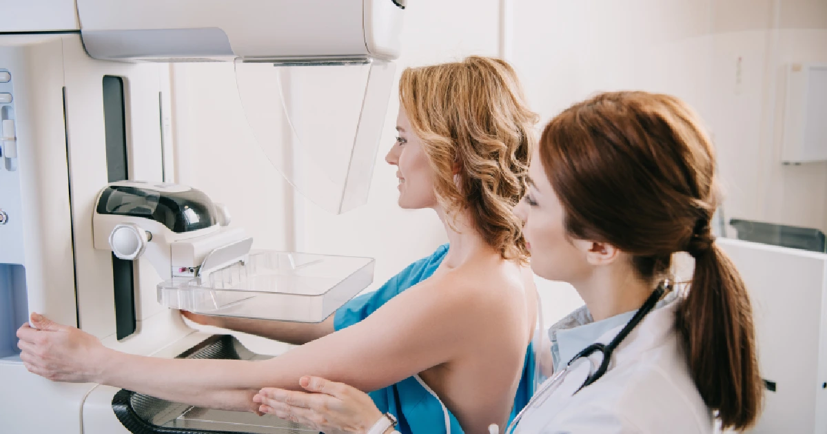 Doctor assisting a woman during her first mammogram screening in Dallas