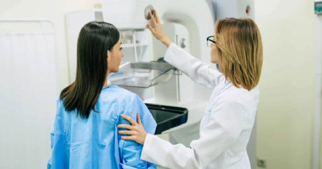 Current image: Female patient receiving a painless mammogram in Dallas, TX, guided by a medical professional using modern breast screening equipment.